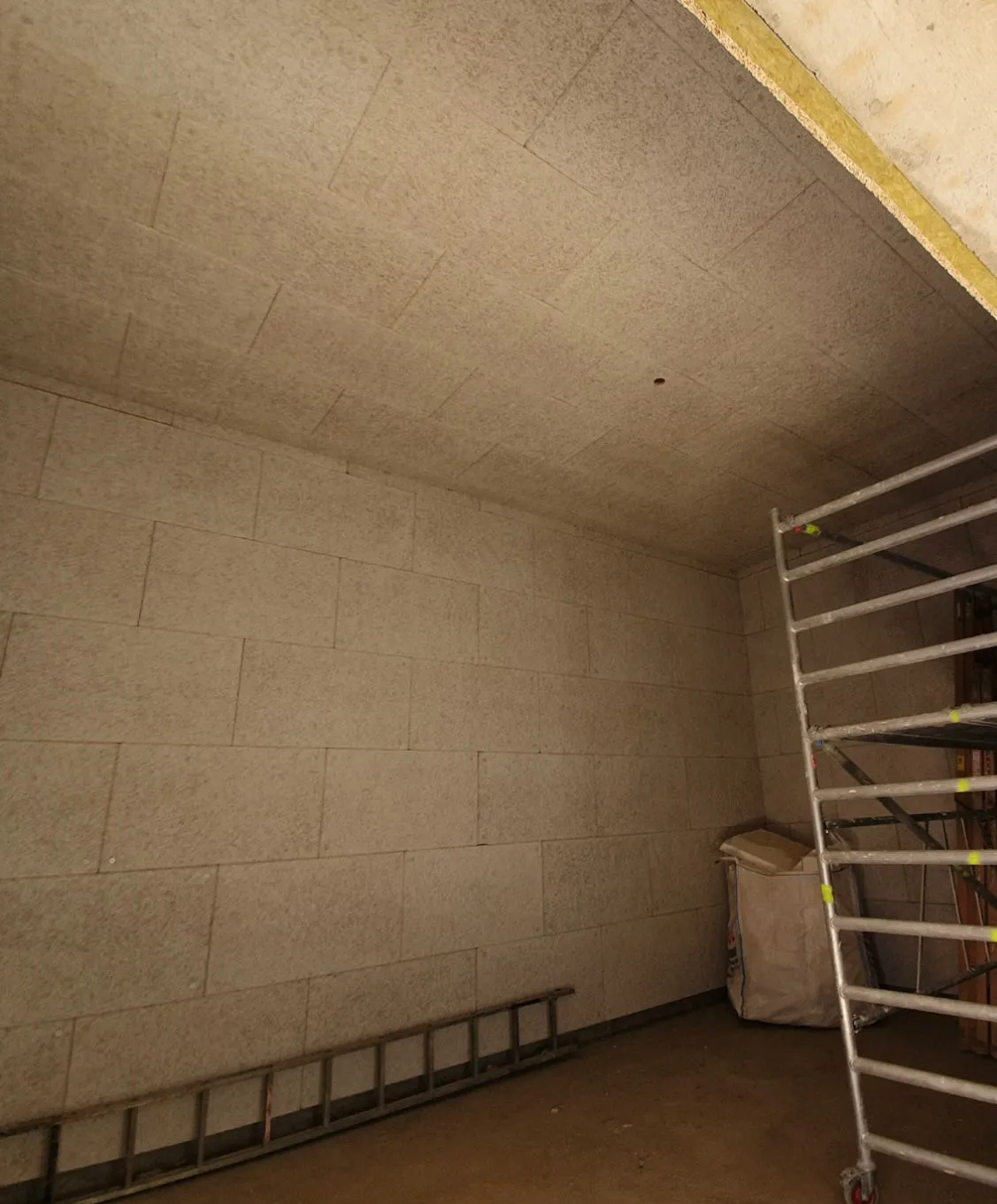 Wełna mineralna na ścianach i suficie w pomieszczeniu z rusztowaniem